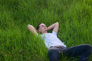 Naklejka na ściany i meble A young boy lying on the grass