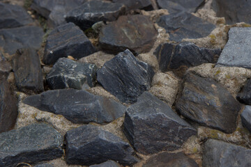 Fototapeta na wymiar Sharp gray stones masonry in cement.