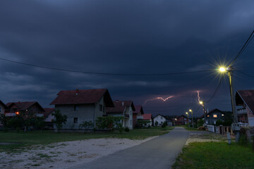 Thunderstorm and dark clouds above suburbs at dusk, bad weather