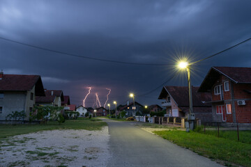 Thunderstorm and dark clouds above suburbs at dusk, bad weather