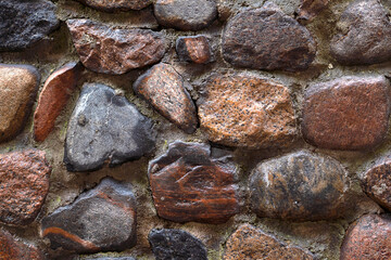 Background of large brown stones. Old road paved with cobblestones. Ancient wall.