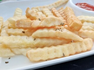 seen some fried potatoes with chili sauce hurt on a white plate