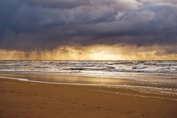 View to the ocean at sunset. Cloudy sky and illuminated horizon. North Holland dune reserve, Egmond...