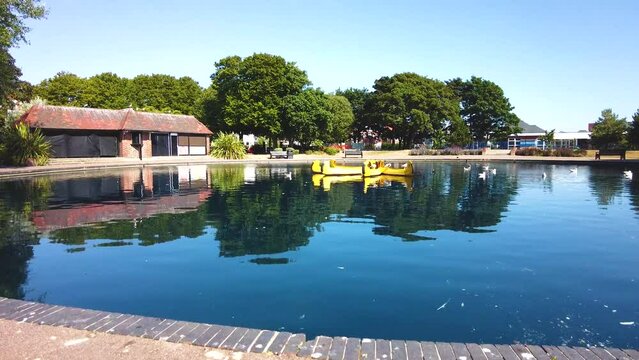 Tilt up and reveal shot of abandoned boating pond in the seaside town of Lowestoft