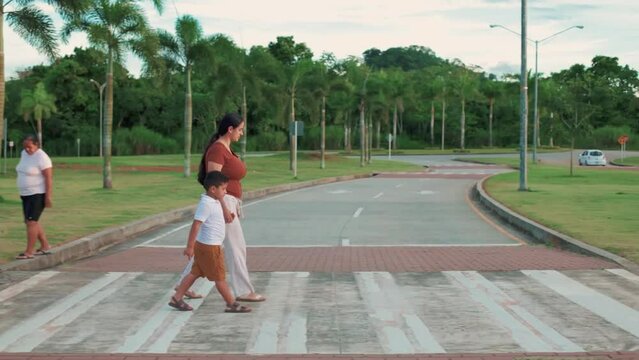 latin family walking down the street, mother holding her son, facing the camera, close-up