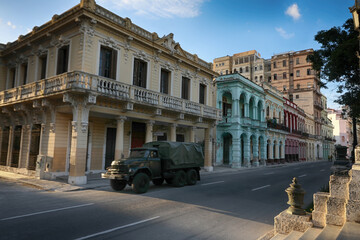 Street scene with classic old cars and traditional colorful buildings in downtown Havana