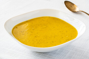 Cream vegetable soup on white table
