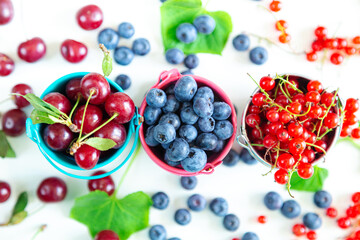 Mix of fresh berries in small buckets. Juicy summer wallpaper.