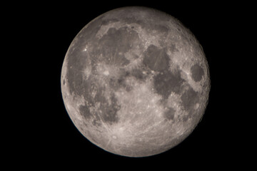 Extreme close up with telephoto lens of full moon in cloudless sky