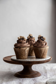 Chocolate cupcakes on a wooden cake stand