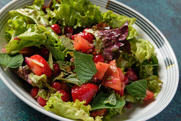 Colorful summer salad with watermelon, strawberries, red currants and mint.