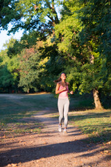 Fototapeta na wymiar Young fitness woman running in summer nature
