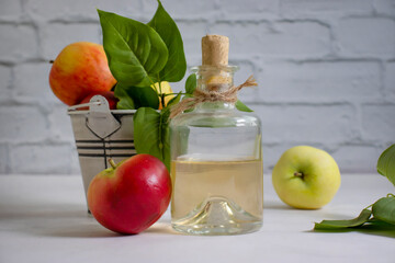 Apple cider vinegar in a bottle, fresh apples
