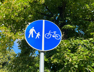 Road sign "Pedestrian and bicycle lane with traffic separation" on the background of blue sky with copyspace