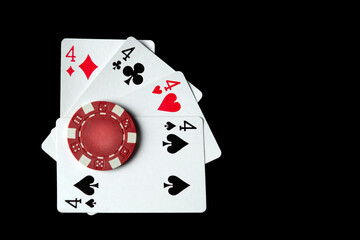 Poker game with quads or four of a kind cards combination. Chips and cards on a black table in a poker club. Luck or fortune in the play.