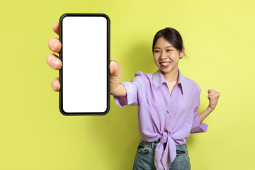 Fototapeta na wymiar Joyful Japanese Lady Showing Huge Phone Gesturing Yes, Yellow Background