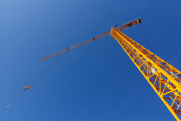 Construction crane on the background of a blue sky. Lifting equipment. Construction