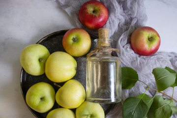 Apple cider vinegar in a bottle, fresh apples