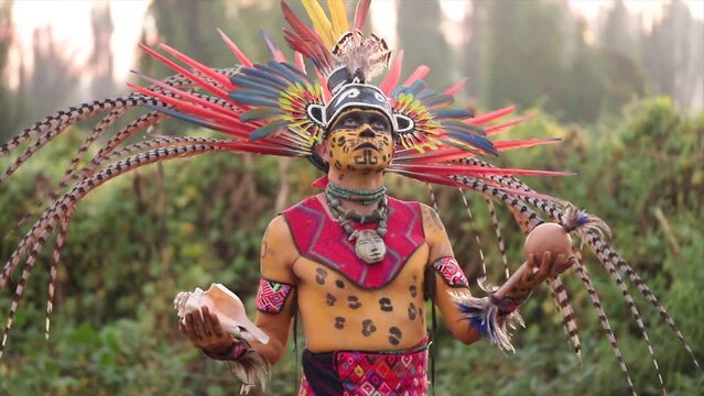 prehispanic indian mexican man dancer with make up and attire of aztec culture with feather plume