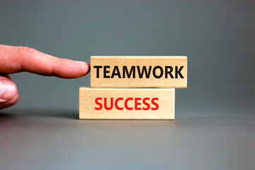 Teamwork success symbol. Concept words Teamwork success on wooden blocks on a beautiful grey table grey background. Businessman hand. Business and teamwork success concept. Copy space.