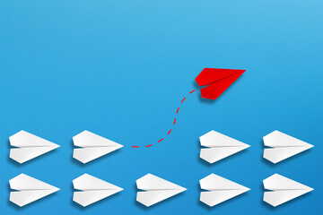 Red paper plane coming out from the advancing white paper planes, different business concept