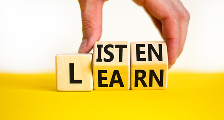 Listen and learn symbol. Businessman turns wooden cubes and changes a concept word Listen to Learn on a beautiful white background. Copy space. Business, educational and listen and learn concept.