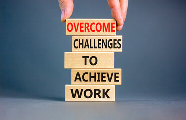 Overcome challenges to achieve goals symbol. Concept words Overcome challenges to achieve goals on wooden blocks on a beautiful grey background. Businessman hand. Business goals concept. Copy space.