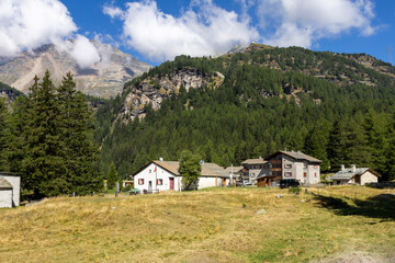 Fototapeta na wymiar Paesaggio delle montagne svizzere. In primo piano un piccolo villaggioSullo sfondo il cielo e nuvole