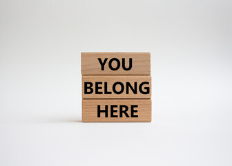 You belong here symbol. Wooden blocks with words You belong here. Beautiful white background. Business and You belong here concept. Copy space.