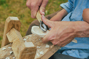 Retro photo. Carpenter carving a spoon close-up