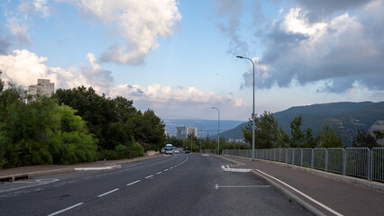 Fototapeta premium A road that crosses a beautiful natural landscape of mountains and hills combined with blue sky and clouds