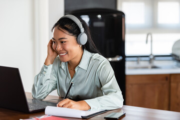 Young Asian women attending online foreign language classes. Sitting in front of a laptop computer...