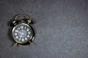 alarm o'clock showing 7 o'clock on gray grunge background
