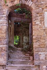 Obraz premium old wooden door in a wall in the medieval centre of oprtalj, croatia