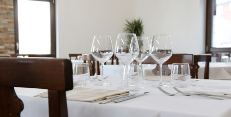 Restaurant table set up with tableware and wine glass. Interior of italian restaurant
