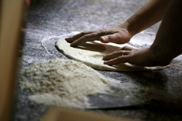 Preparing Pizza dought on a marble countertops. Chef pizza maker