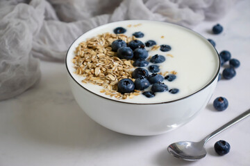 Yogurt, oatmeal, blueberries on a light background