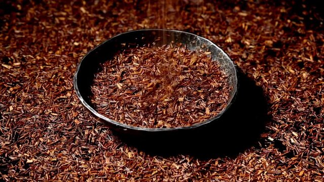 rooibos tea in a bowl, made from the South African red bush, naturally caffeine free - low angle view on turntable