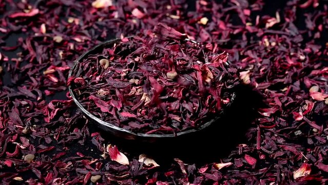 Falling Dried leaves of hibiscus red dry tea background, close up. rotation.