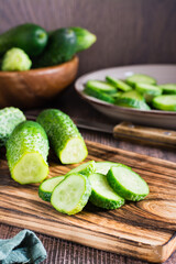 Fresh sliced cucumbers on a cutting board on the table. Organic diet food. Vertical view