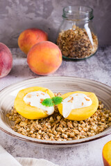 Peach halves filled with yogurt on granola on a plate. Korean trendy Greek momo. Vertical view