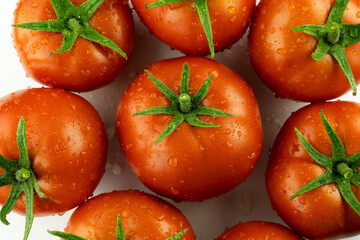 A red tomato highlighted on a white background with an edged leg. Stack of images macro photography with full depth of field.