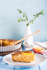 A piece of peach pie on a plate on the table. Homemade pastries. Vertical view