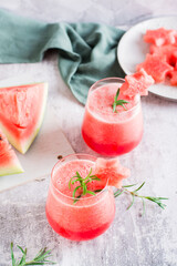 Cold watermelon drink in glasses on the table. Summer refreshing cocktails. Vertical view