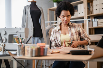 Fototapeta na wymiar Young black entrepreneur women working in her workshop. Woman tailor.