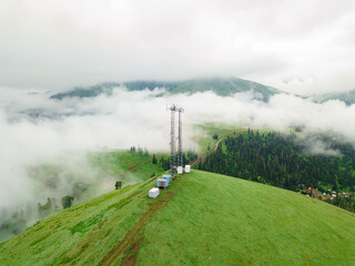View from the drone to the GSM tower and radio communications in the mountains in the clouds. Cell...