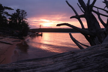 Sunset with driftwood on Lake Superior in Upper Peninsula Michigan