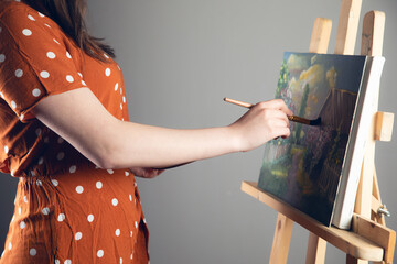 Woman artist holding paint brush on  canvas