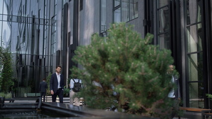 Fototapeta na wymiar Confident businessman walking downtown office building. Successful entrepreneur