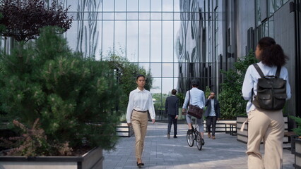 Corporate people going to workplaces in morning at modern glass office building.